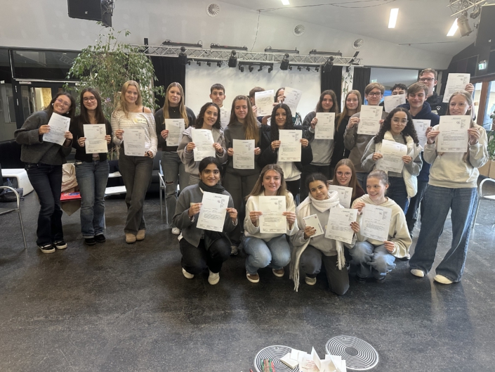 Teilnehmende präsentieren ihre Teilnahmezertifikate